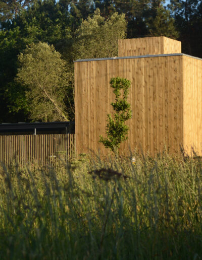 Casa de dos plantas con estructura de hormigón y fachada de madera