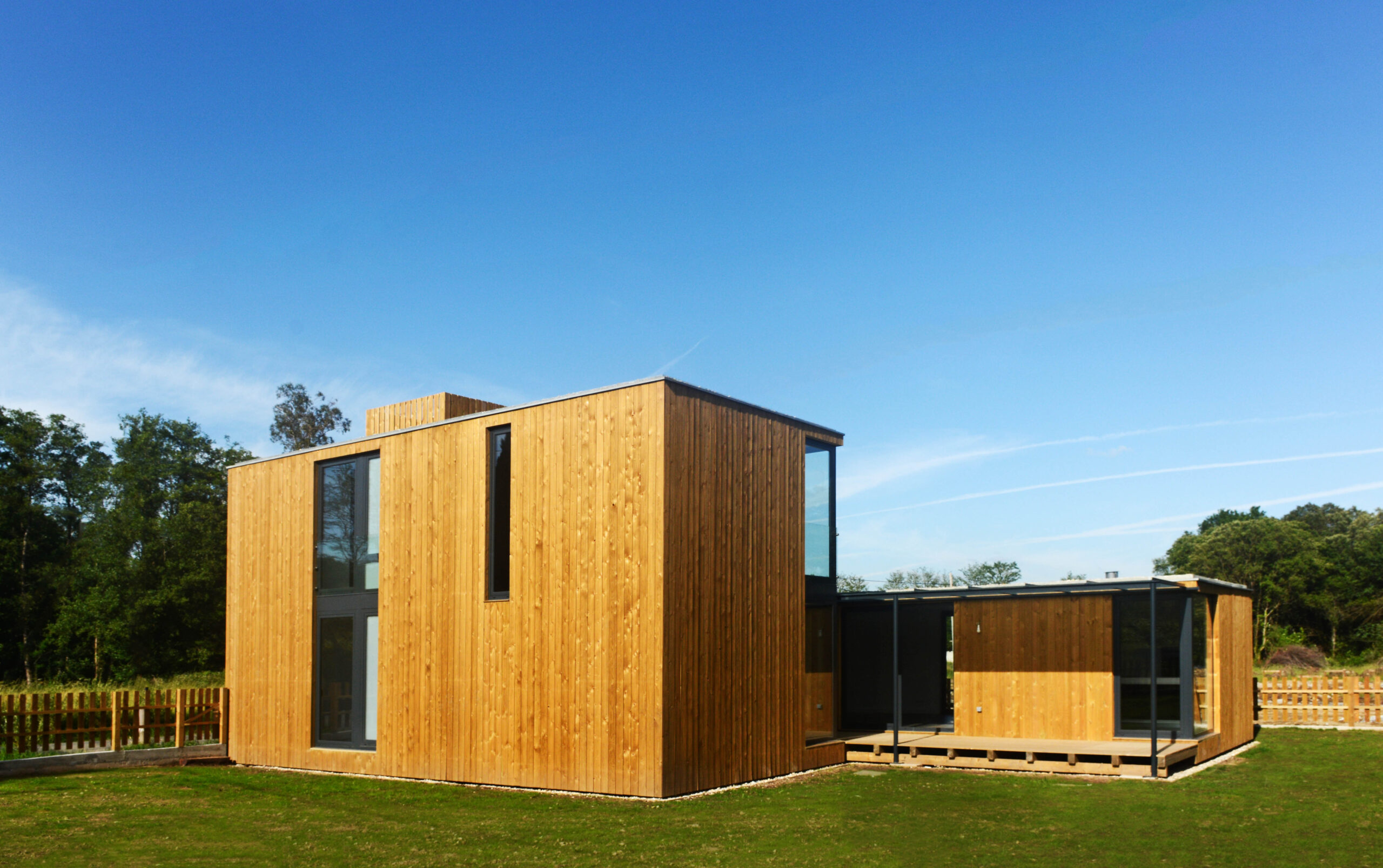 Casa de dos plantas con estructura de hormigón y fachada de madera