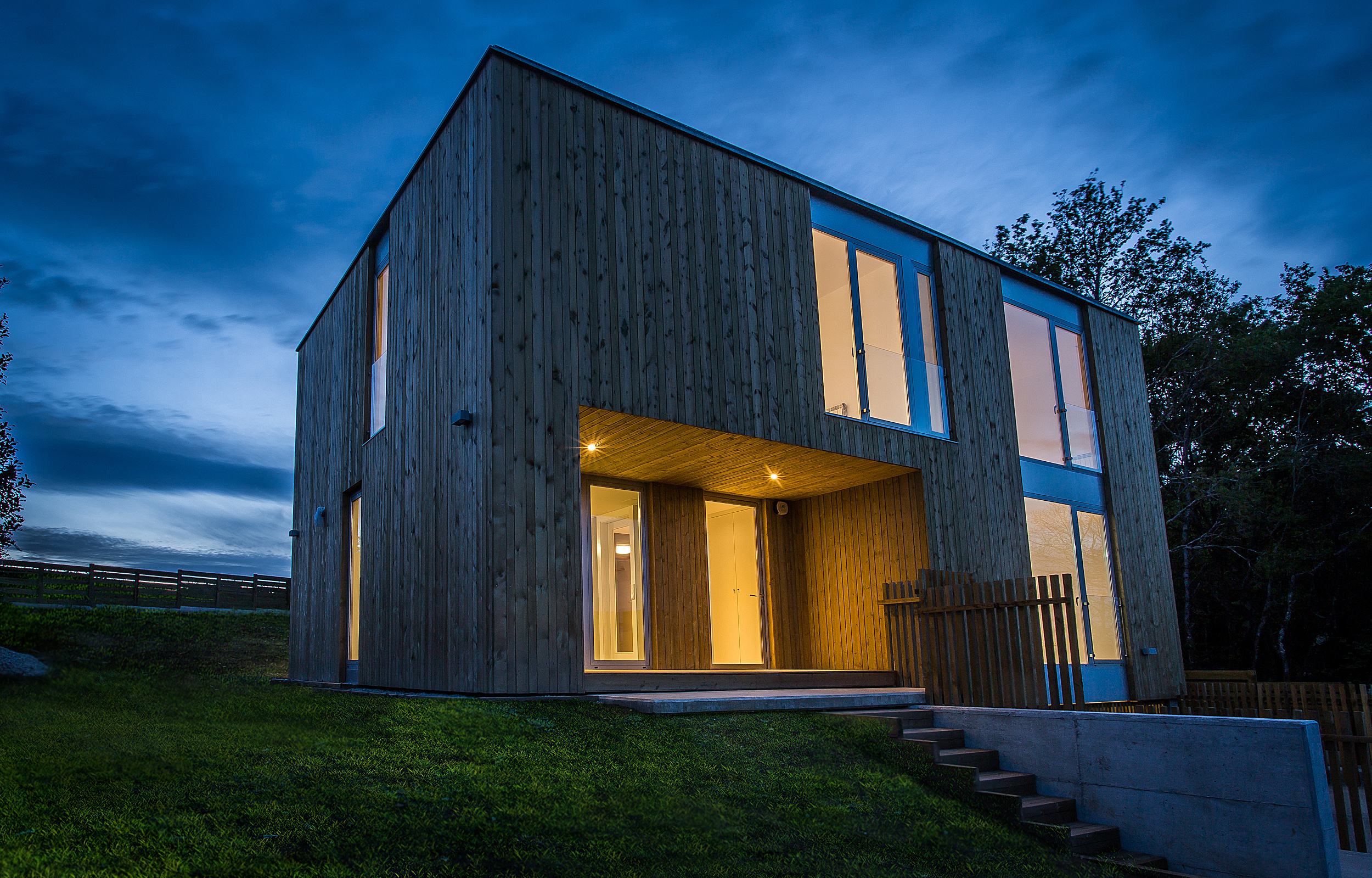 Casa de hormigón con fachada de madera y semisótano