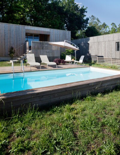 Fachada de madera y piscina