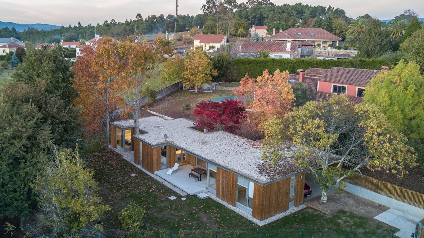 Casa de hormigón y madera rodeada de árboles