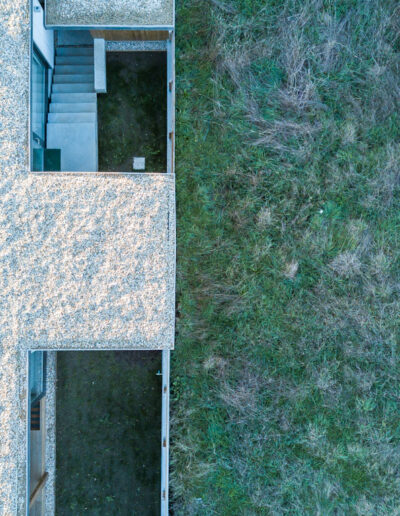 Casa de hormigón con fachada de piedra y madera