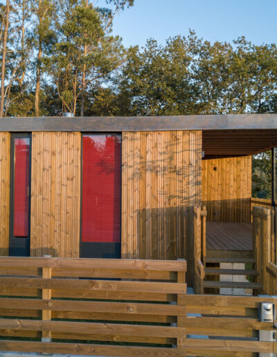 Acceso casa de hormigón con fachada de madera