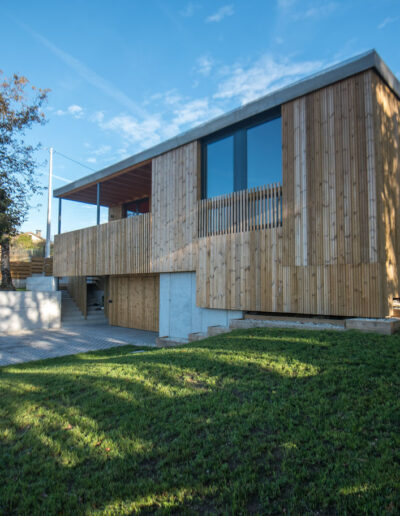 Casa de hormigón con fachada de madera y semisótano